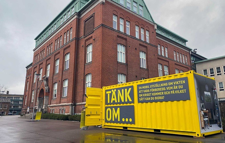 gul container framför skola